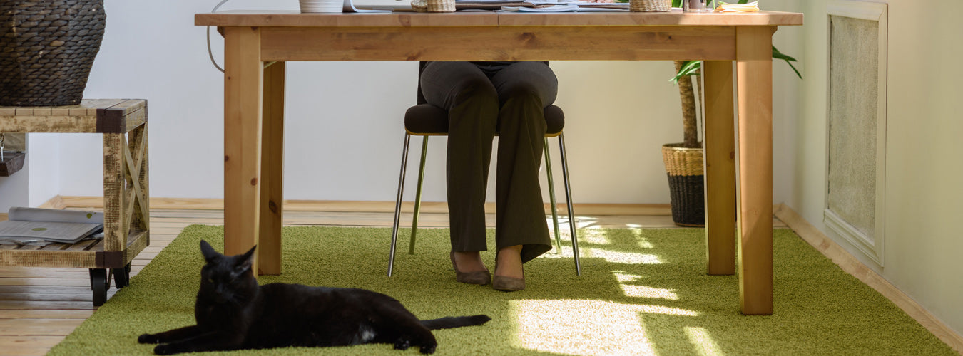 A woman is working at her desk in a beautiful indoor environment. Matace Removable Carpet tiles under her desk!